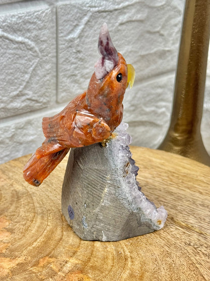 Orange crystal bird carving on amethyst cutbase from Brazil