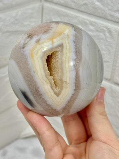Beautiful banded agate sphere with druzy from Brazil