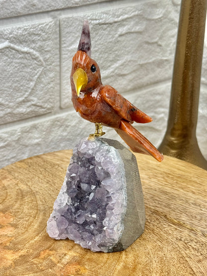 Orange crystal bird carving on amethyst cutbase from Brazil