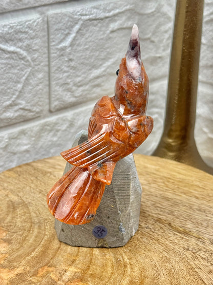 Orange crystal bird carving on amethyst cutbase from Brazil